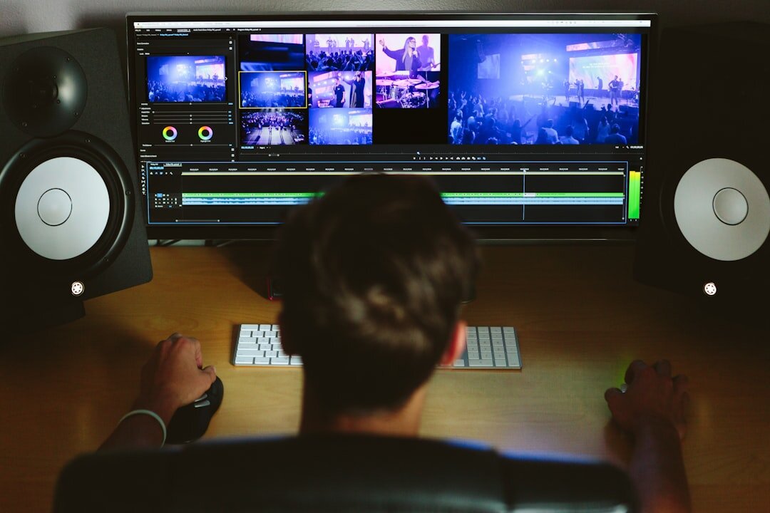 Video editor working on footage timeline at a desk with monitors