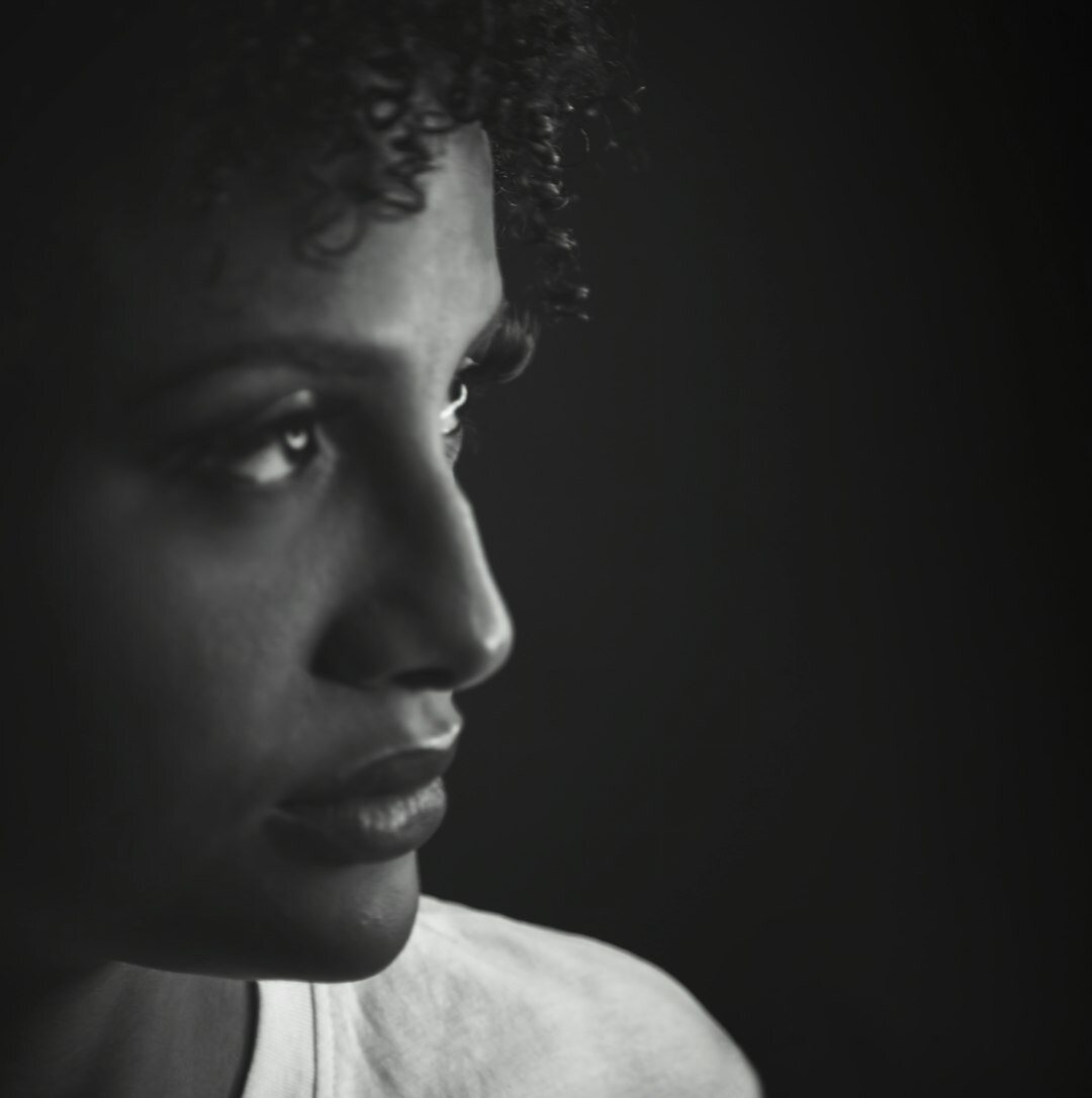 Studio portrait of a woman with curly hair, head of training