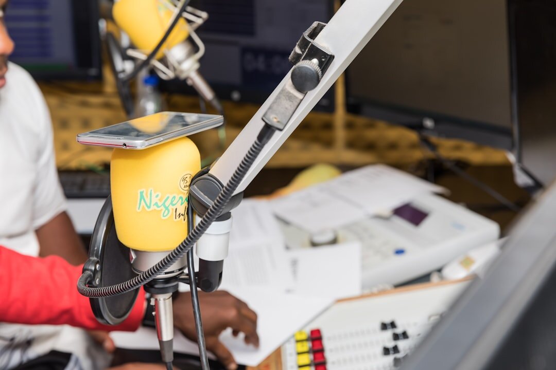 Diverse newsroom team collaborating near a microphone and recording setup